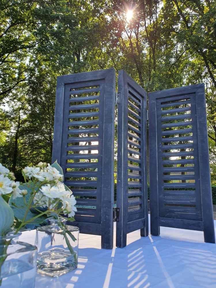 Fensterladen schwarz 52 cm draußen im Gegenlicht mit Blumen