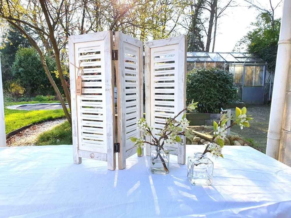 Fensterladen Deko weiß 52 cm auf einem Gartentisch mit Blütenzweigen